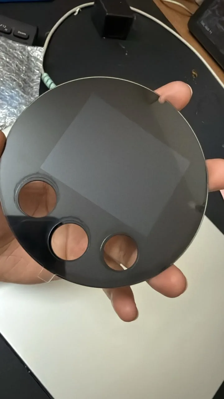 Round tinted cover lens with a rectangular display window and three button holes