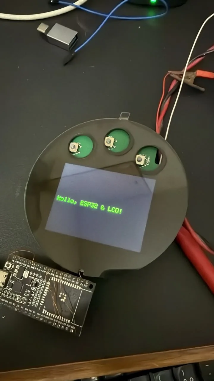 ESP32 dev board wired to the round faceplate with the LCD showing a test message